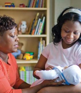 home visitor assists mother holding baby