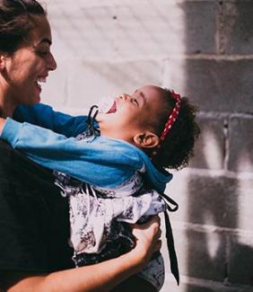 mother holding child and laughing